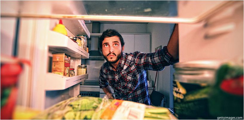 l'homme regarde dans le réfrigérateur
