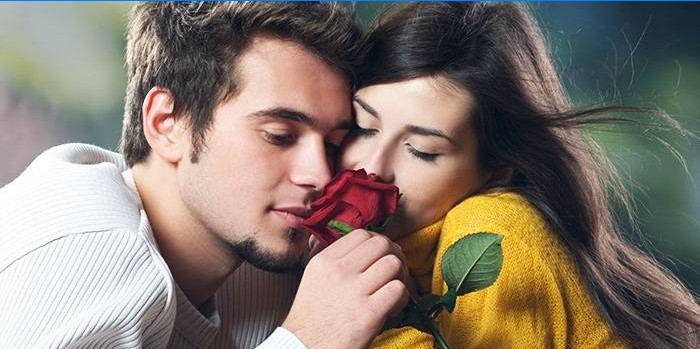 Guy et fille reniflant une rose