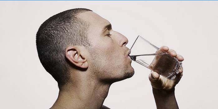 Un homme boit de l'eau sur un régime rapide pour perdre du poids