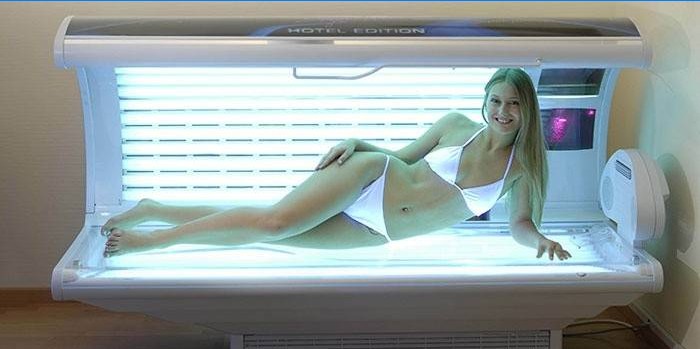 Fille dans un lit de bronzage horizontal