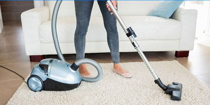 Fille aspire un tapis