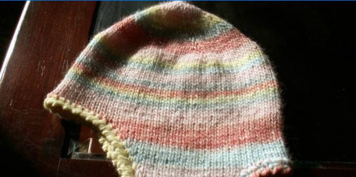 Un bonnet avec oreillettes pour un garçon tricoté de ses propres mains sur des aiguilles à tricoter