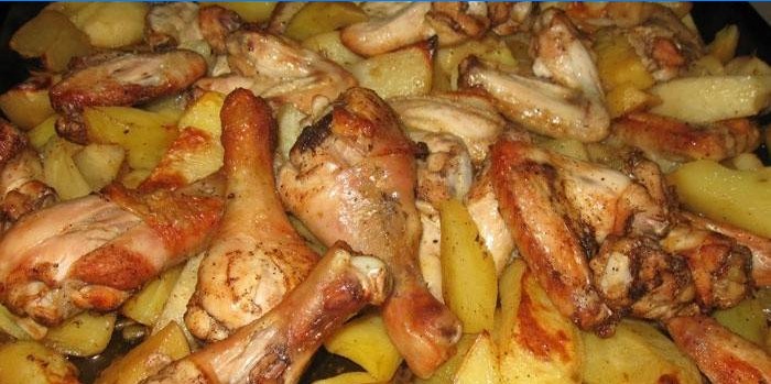 Cuisses de poulet aux pommes de terre sur une plaque à pâtisserie