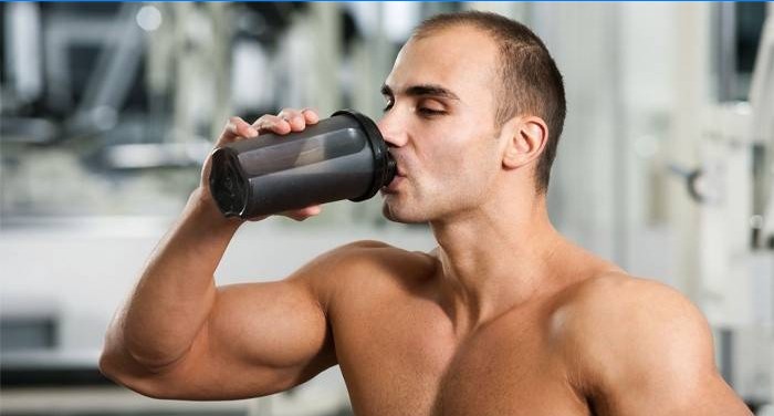 Bodybuilder boit un cocktail