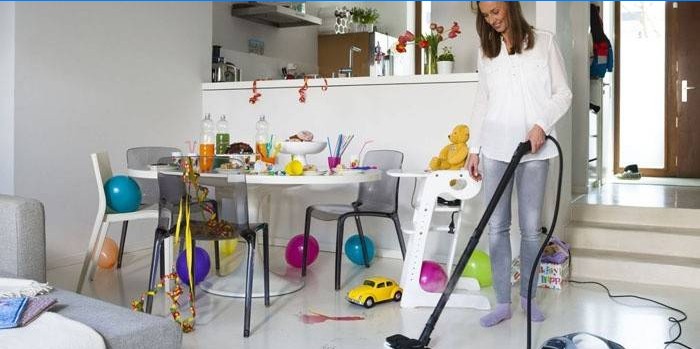 La jeune fille passe l'aspirateur dans l'appartement