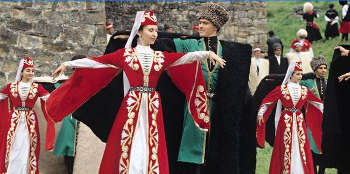 Des femmes et des hommes en costumes tchétchènes dansent
