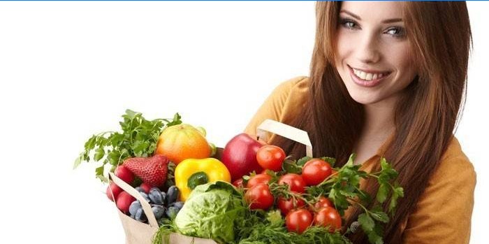 Fille avec paquet de légumes et fruits.