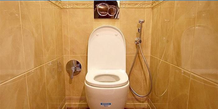 Douche hygiénique sur le mur près des toilettes