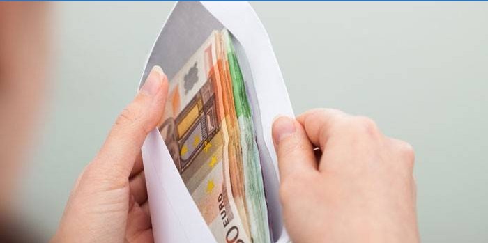 L'argent dans une enveloppe entre les mains
