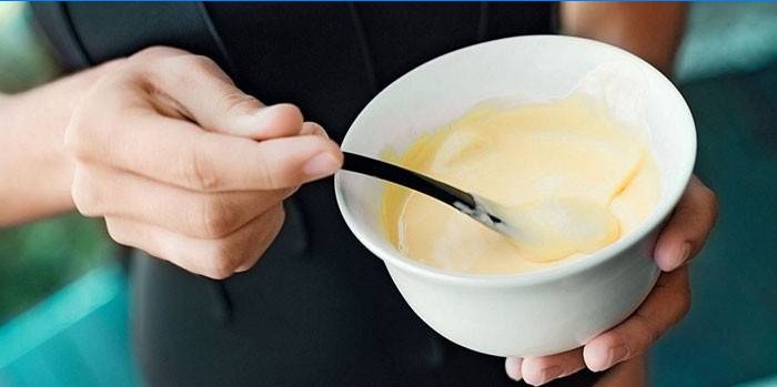 Fille mélange le kéfir au citron dans une assiette
