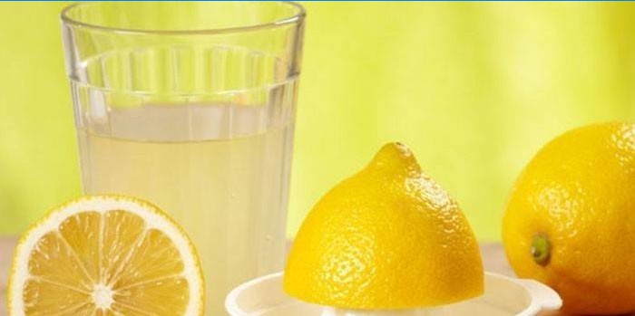 Jus de citron dans un verre et citrons