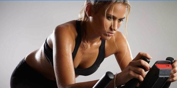 Fille s'entraîne sur un vélo d'exercice