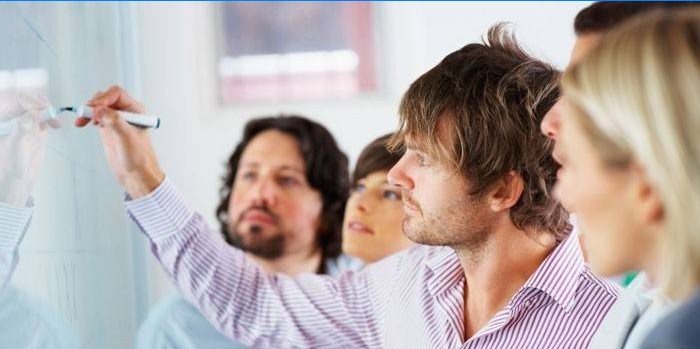 Les gens à la formation près du tableau noir