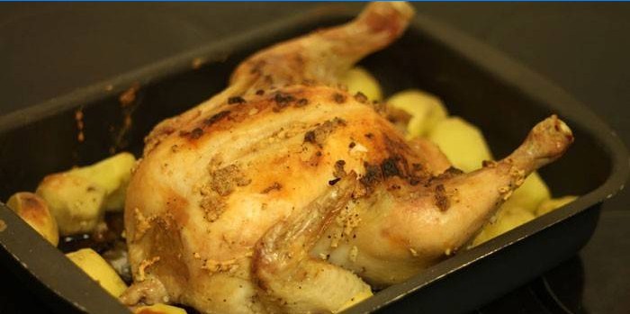 Poulet entier avec pommes de terre dans une plaque à pâtisserie