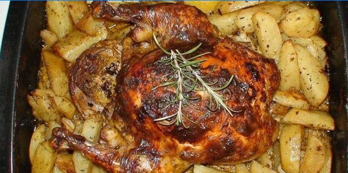 Poulet sur un oreiller de pommes de terre sur une plaque à pâtisserie