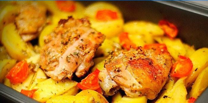 Cuisses de poulet au four avec pommes de terre sur une plaque à pâtisserie