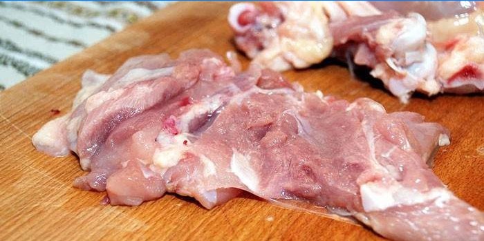 Cuisse de poulet désossée sur une planche à découper