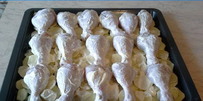 Pilons de poulet en mayonnaise avec pommes de terre avant cuisson