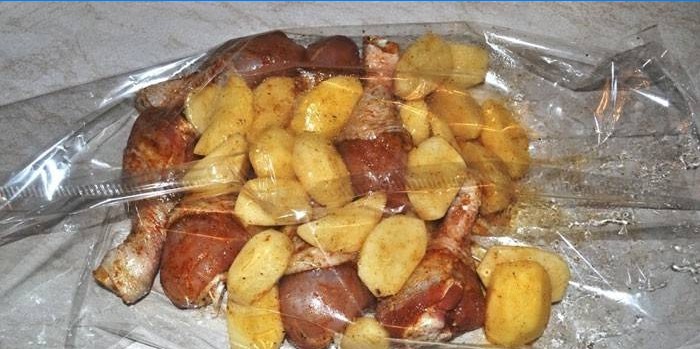 Pilons de poulet marinés avec pommes de terre dans une manche de cuisson