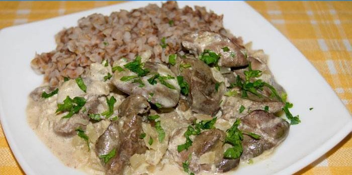 Foie dans une sauce à la crème sure avec du sarrasin sur une plaque