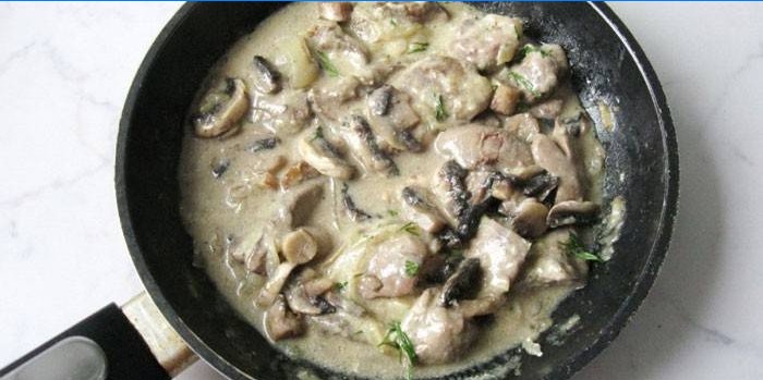 Foie de poulet aux champignons dans une sauce à la crème sure dans une poêle