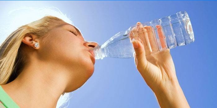 Fille boit de l'eau provenant d'une bouteille