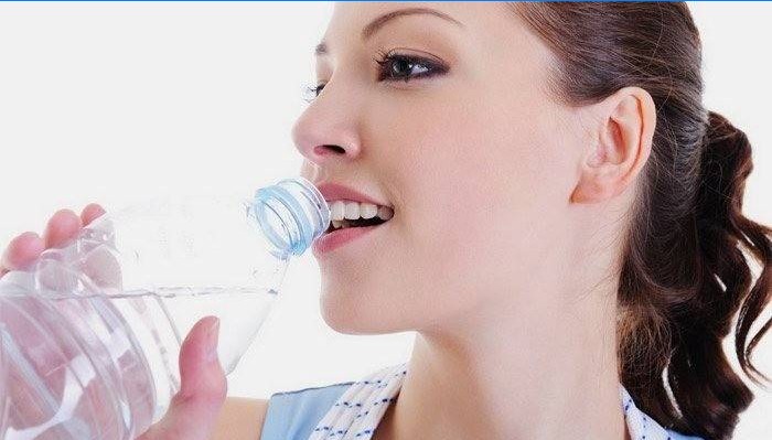 Fille boit de l'eau pour perdre du poids.