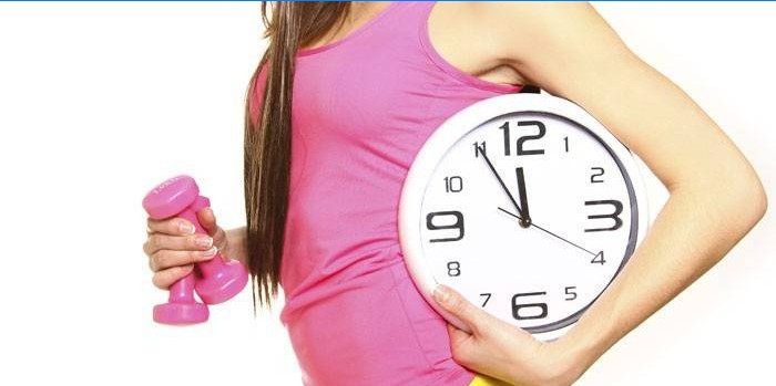 Fille avec une horloge et un haltère