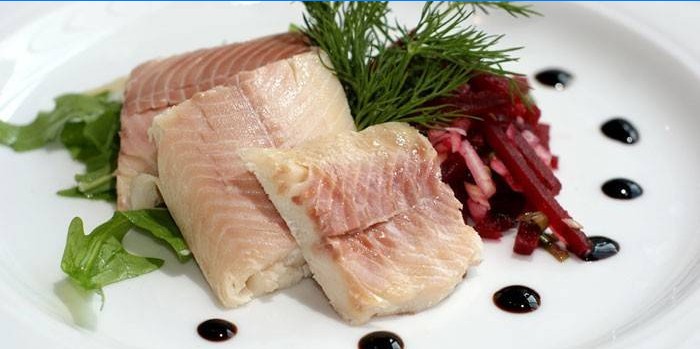 Filet de poisson avec salade sur une assiette