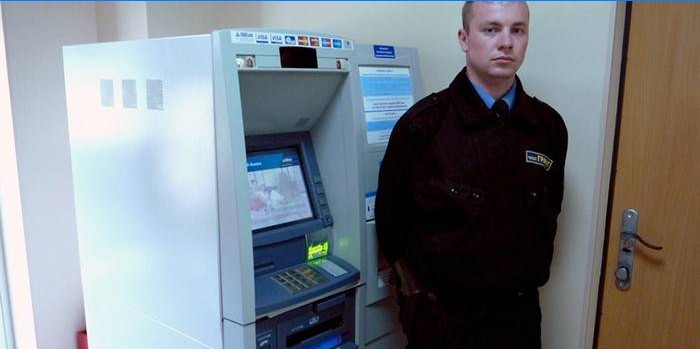 Agent de sécurité près du guichet automatique