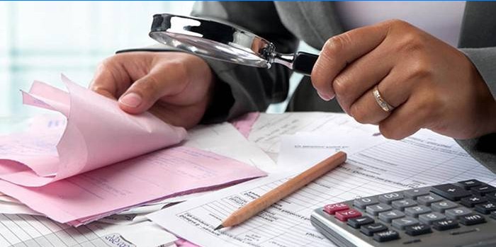 Un homme examine le papier à travers une loupe