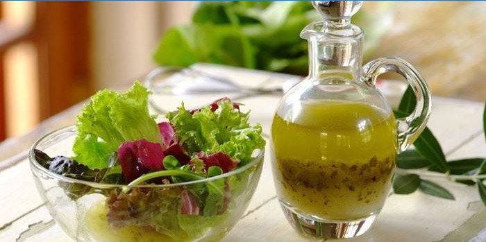 Feuilles de salade dans un bol et vinaigrette toute prête pour la vinaigrette