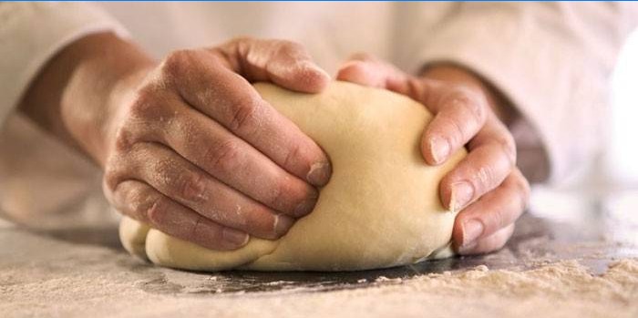 L'homme pétrit la pâte.