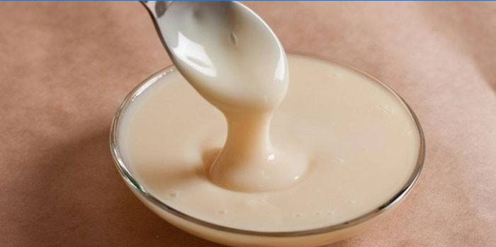 Lait condensé dans une cuillère et une rosette