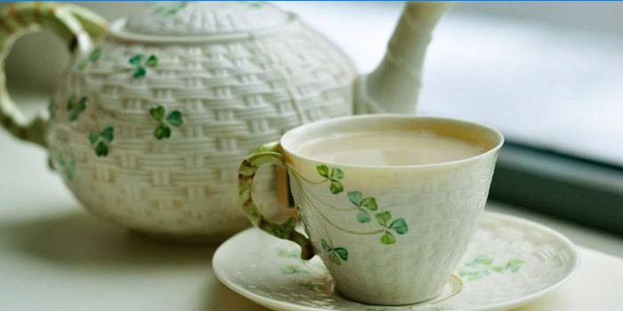 Thé vert avec du lait dans une tasse et une théière
