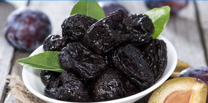 Pruneaux en assiette et prunes mûres