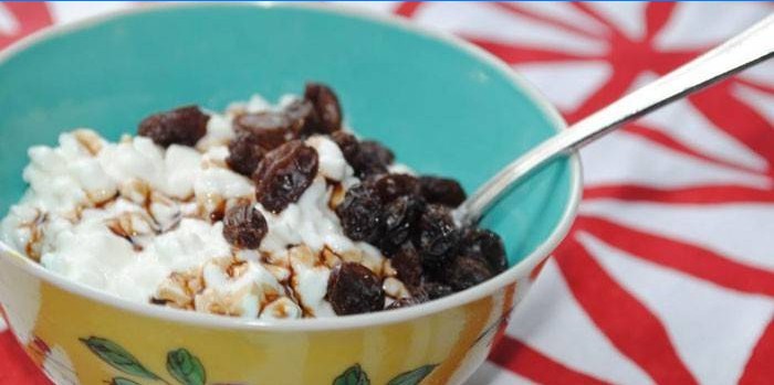 Fromage cottage aux raisins secs et pruneaux dans une assiette