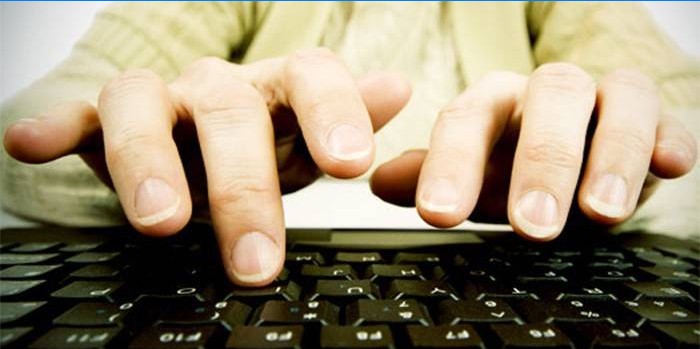 Doigts d'un homme au-dessus d'un clavier d'ordinateur