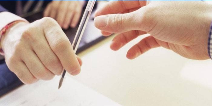 Un homme donne un stylo à un autre homme