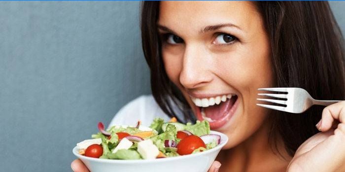 Fille tient une assiette avec salade