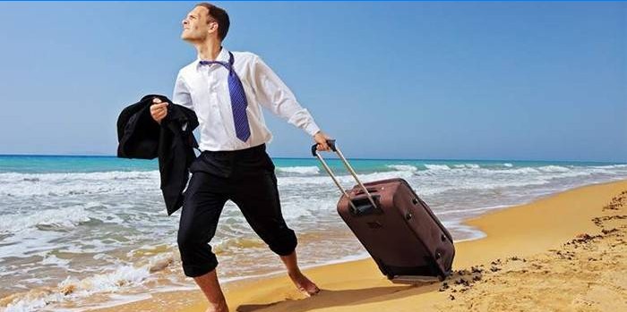 Homme avec une valise sur la plage