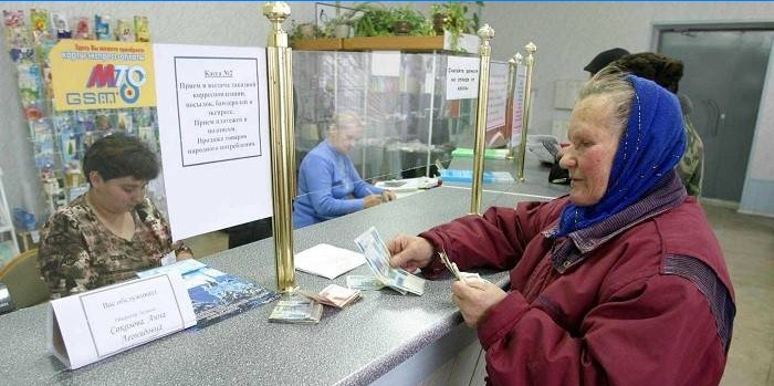 Une femme reçoit une pension au bureau de poste