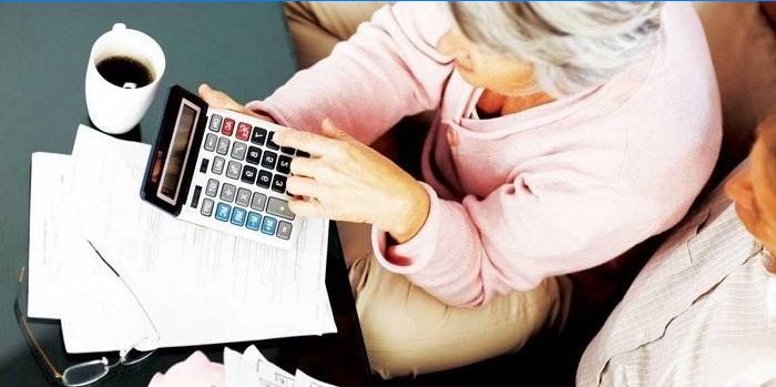 Couple de personnes âgées avec une calculatrice, des documents et une tasse de café