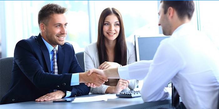 Jeune couple et employé de banque conclure un accord