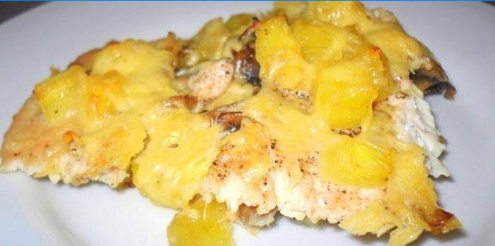 Un morceau de poulet avec pommes de terre, ananas et fromage