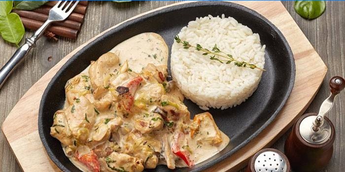 Poulet tranché dans une sauce crémeuse avec du riz garni