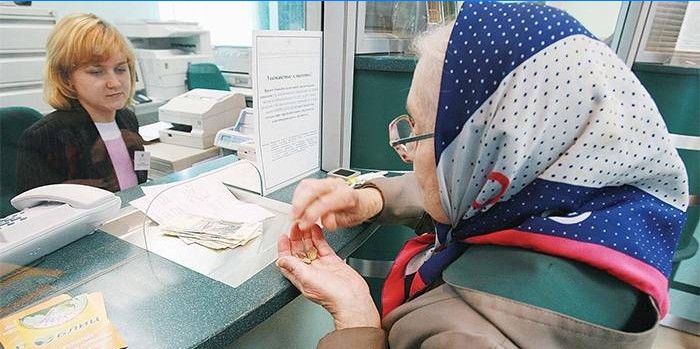 Une femme âgée reçoit une pension à la banque