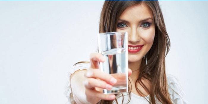 Fille avec un verre d'eau à la main