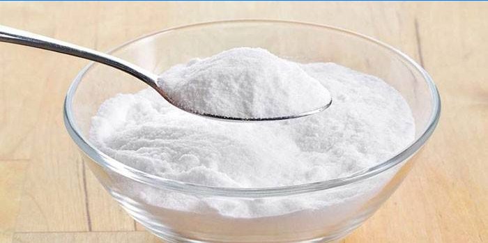 Bicarbonate de soude dans une cuillère et une assiette