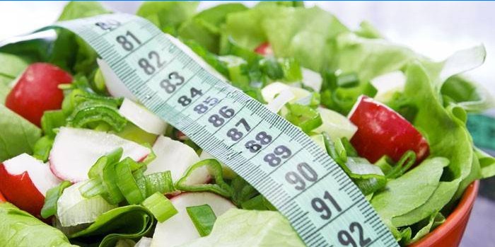 Salade de légumes dans une assiette et une bande de centimètre